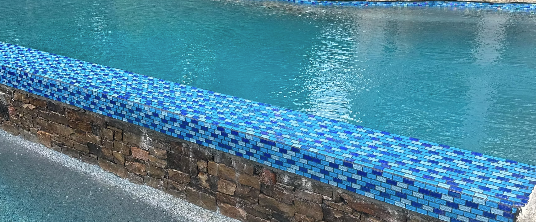 A swimming pool with blue tiles on the edge of it.