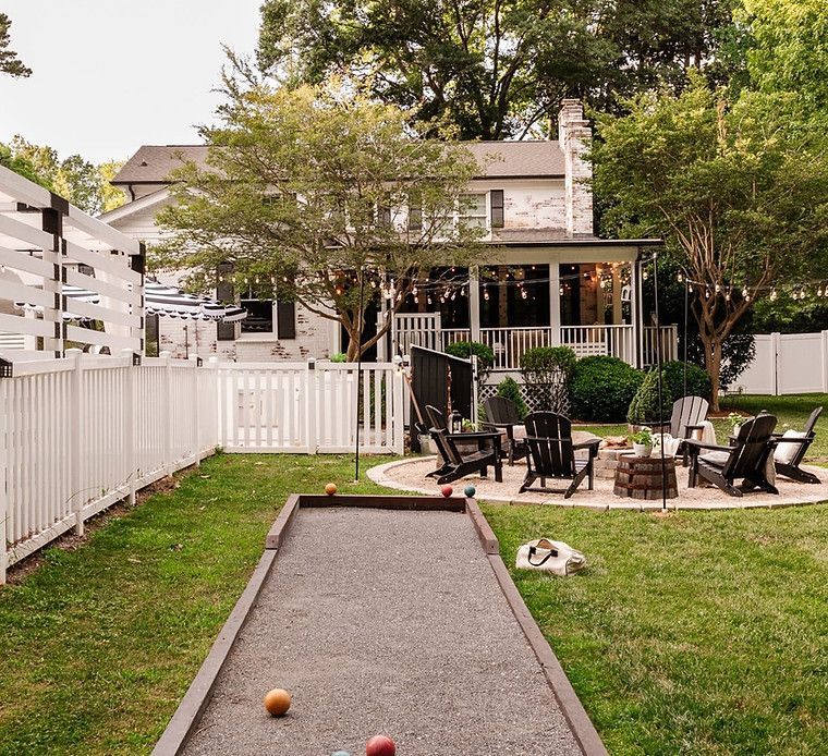 There is a bocce ball court in the backyard of a house.