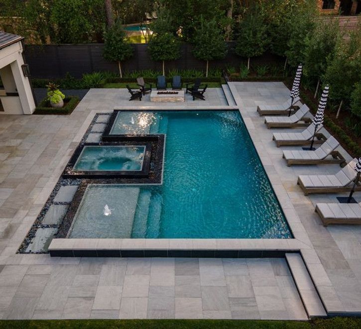 A large swimming pool surrounded by chairs and umbrellas