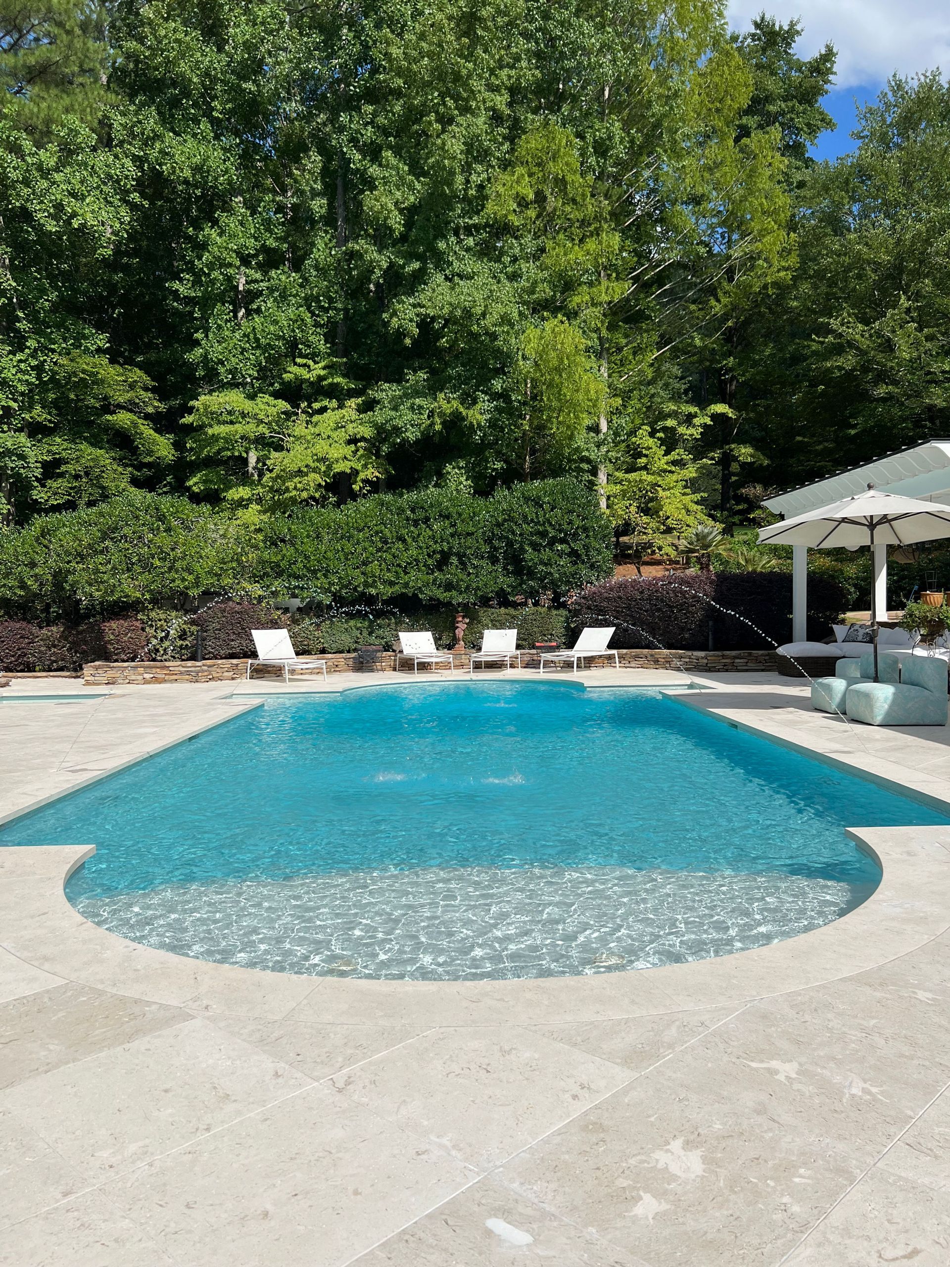 A large swimming pool with a gazebo in the background