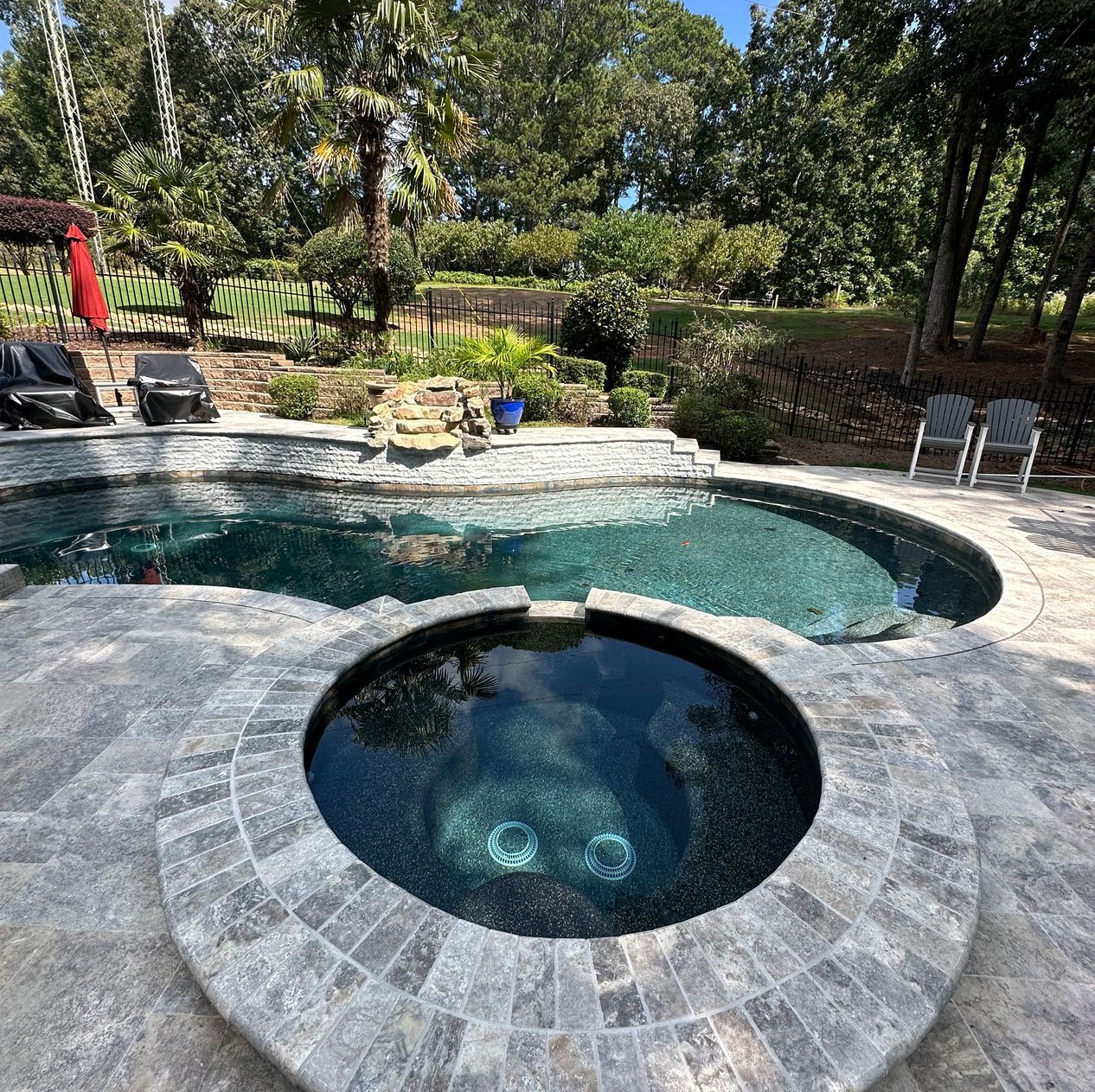 A large swimming pool with a hot tub in the middle