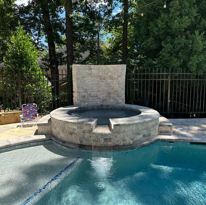 A large swimming pool with a hot tub in the middle of it.