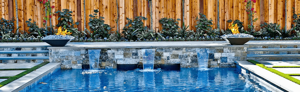 A large swimming pool with a wooden fence in the background.