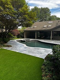 There is a large swimming pool in the backyard of a house.