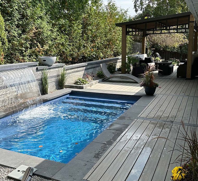 A large swimming pool with a waterfall in the backyard