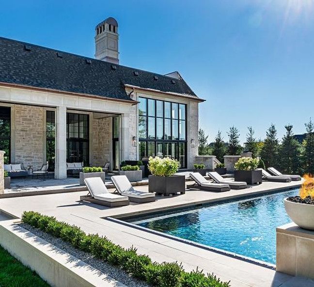 A large house with a large swimming pool in front of it.