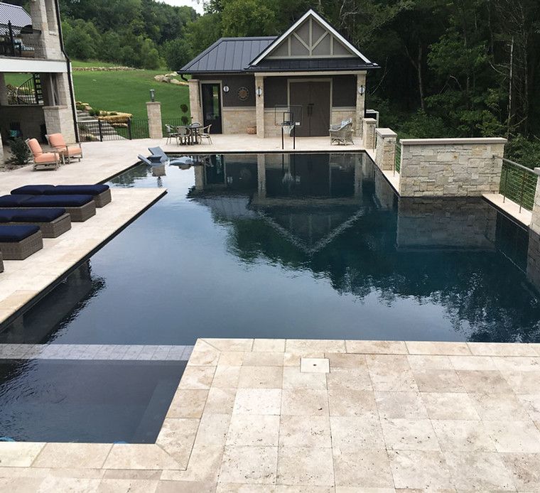 A large swimming pool with a house in the background