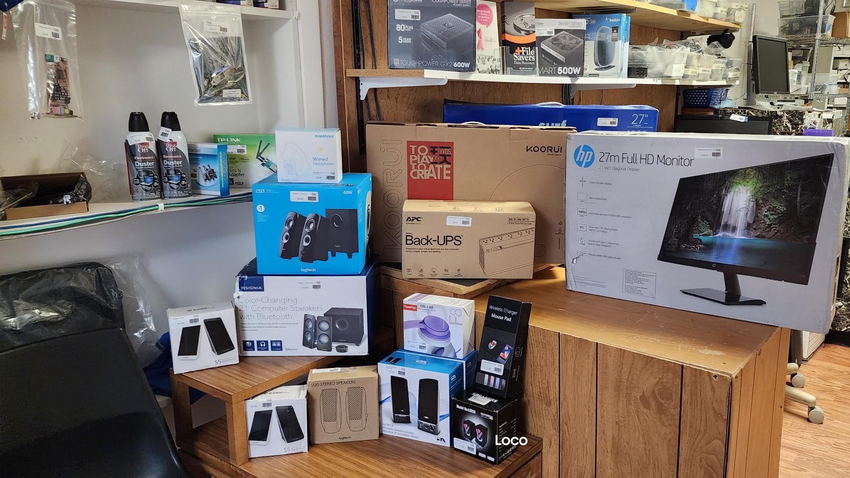 a computer store with boxes and a monitor on a table .