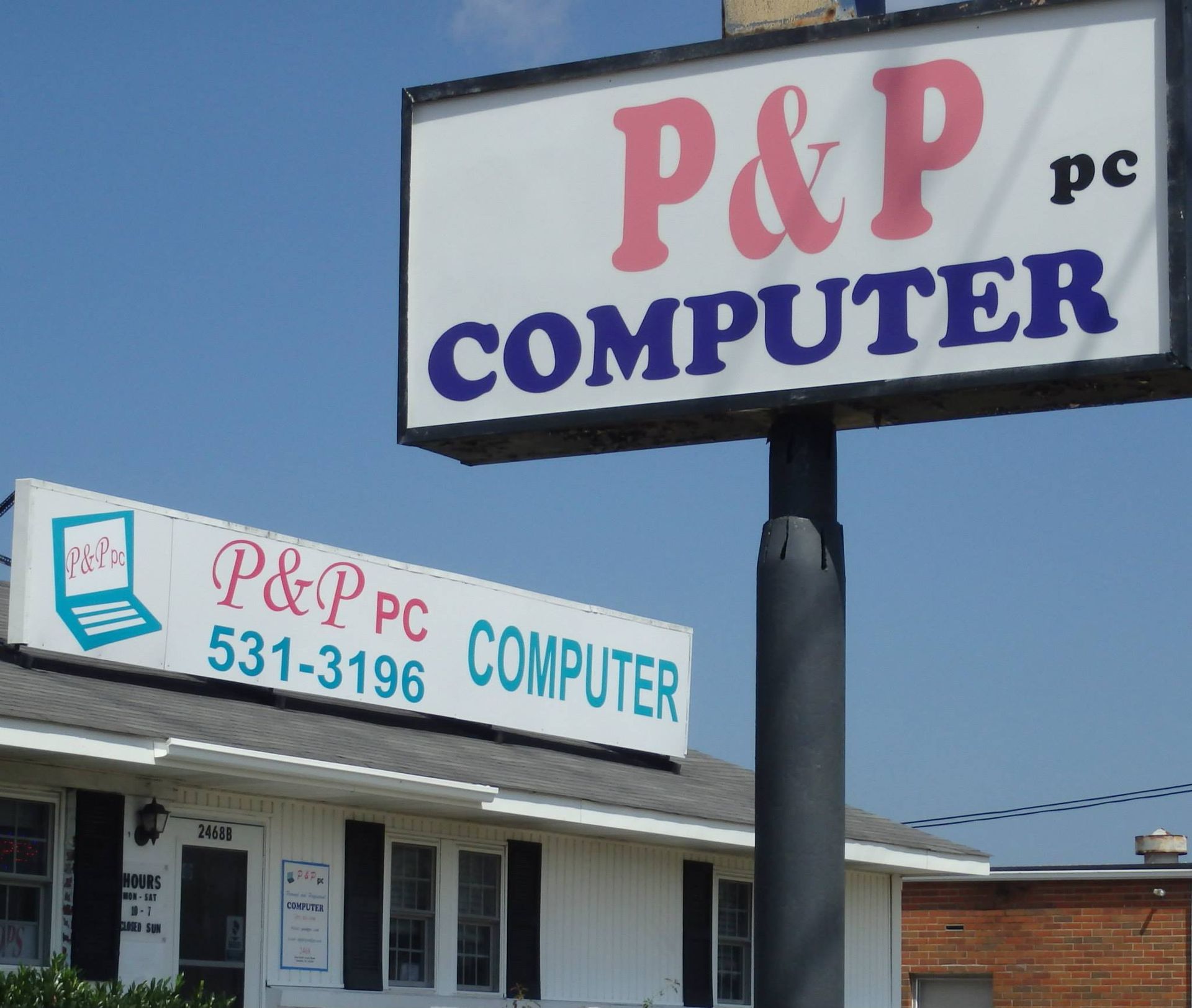 a sign for p & p computer in front of a building