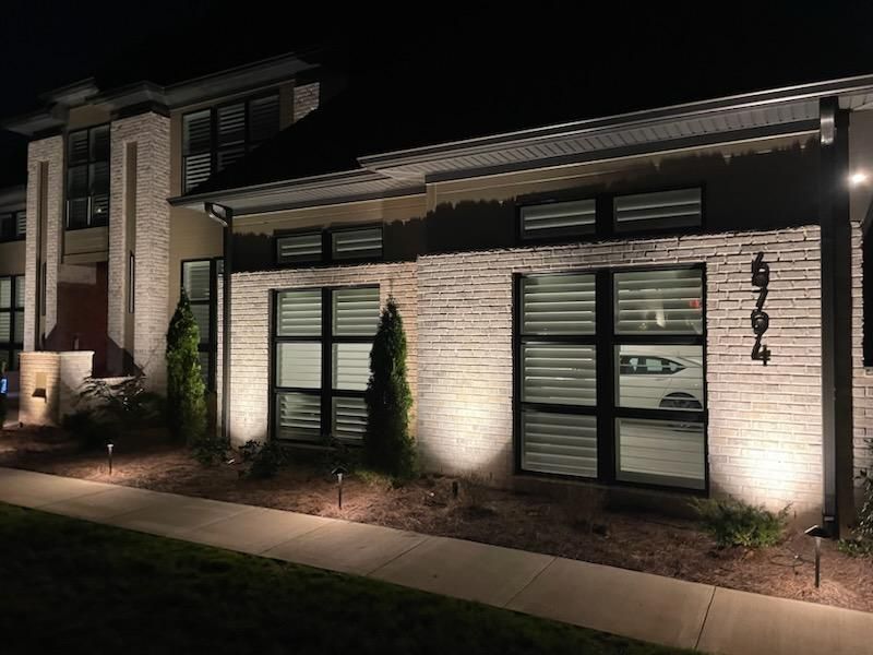 Walking path along a brick house is list at night