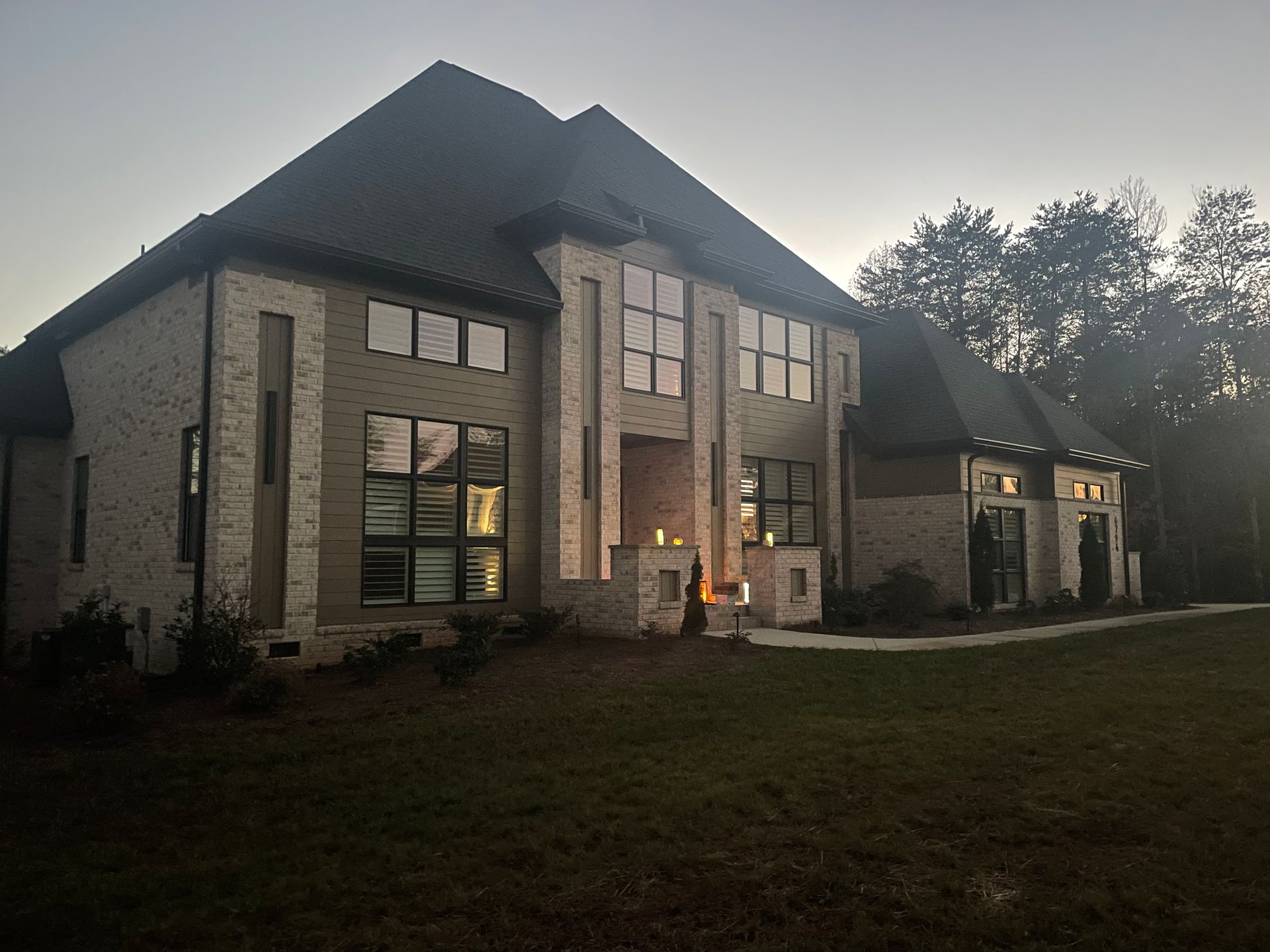 A large house with a lot of windows is lit up at night.