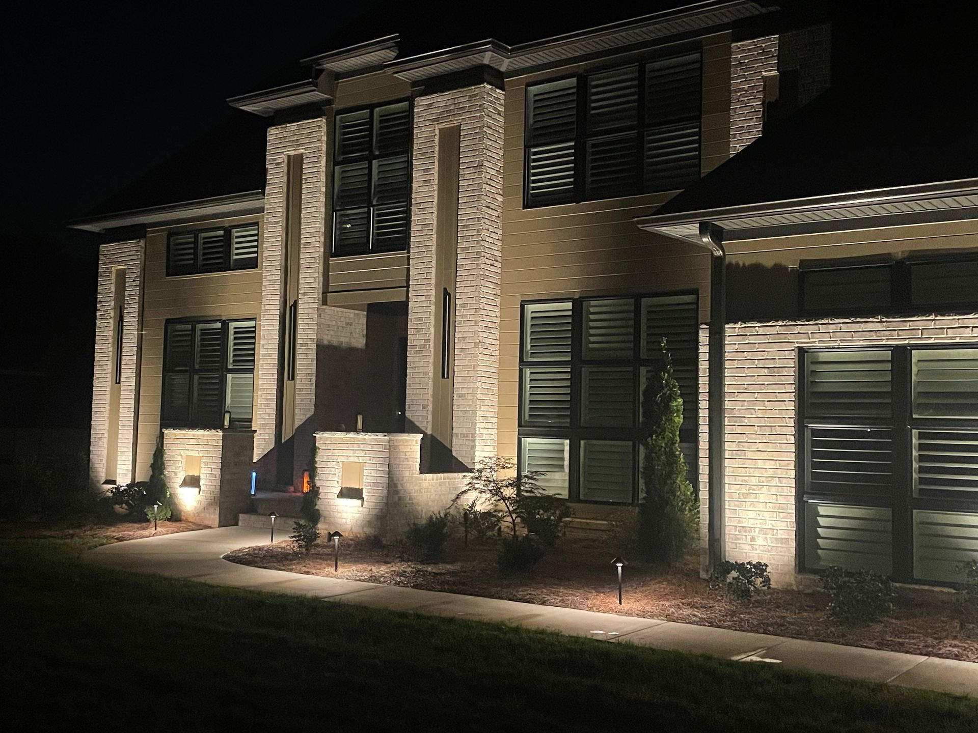 A large brick house is lit up at night.