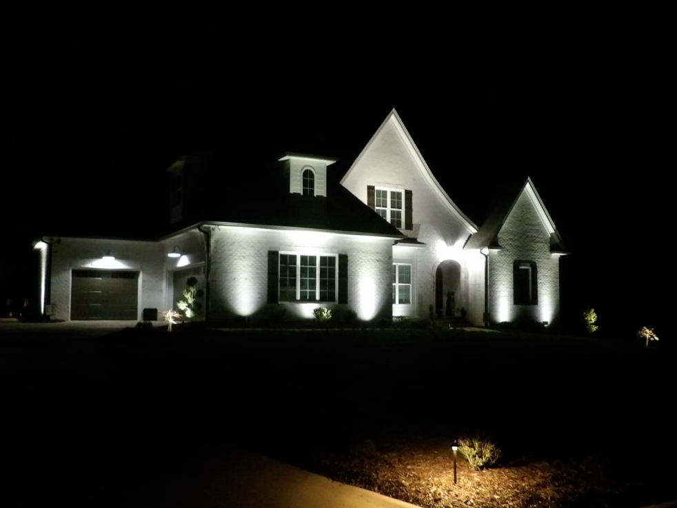 A large white house is lit up at night