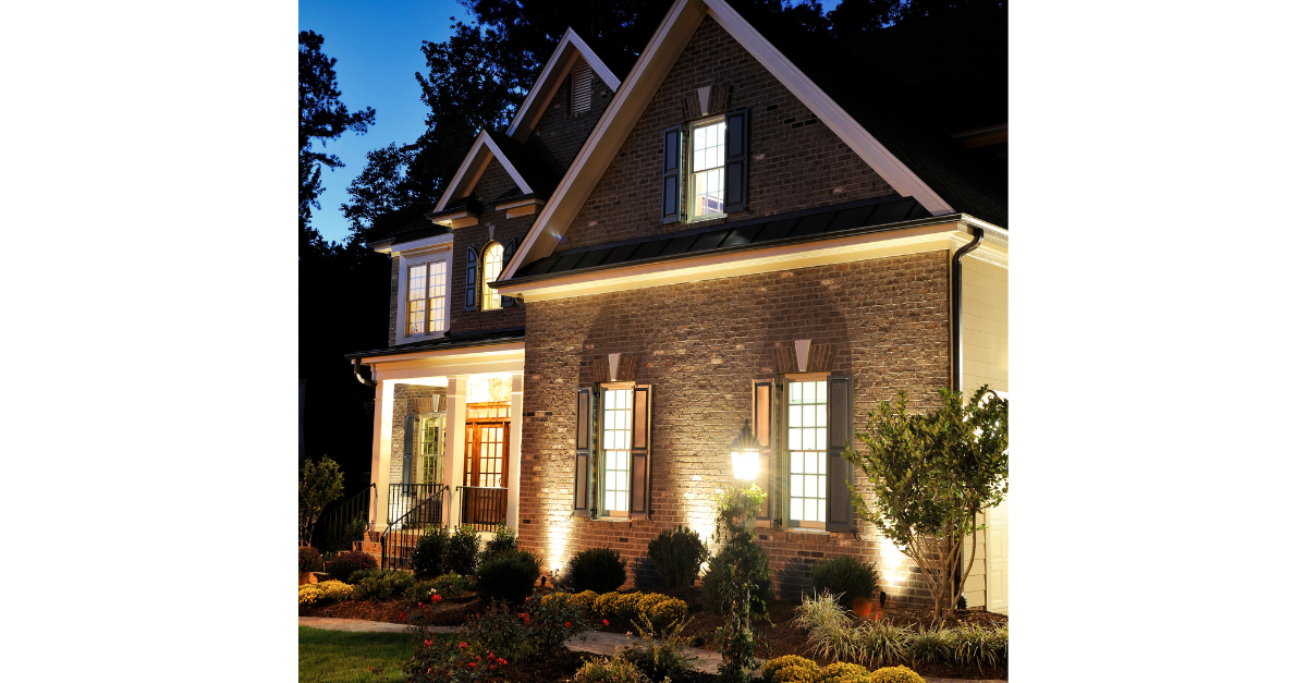 A large brick house is lit up at night.