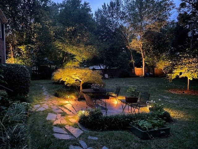 A group of people are sitting on pillows watching a movie on a projector screen.