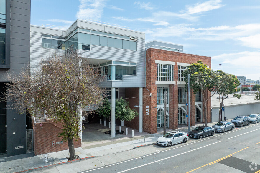 A row of cars are parked in front of a large building.