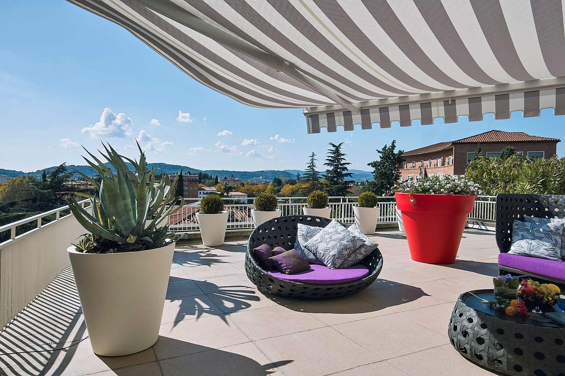 A retractable awning over a backyard patio with modern furniture and a gorgeous view