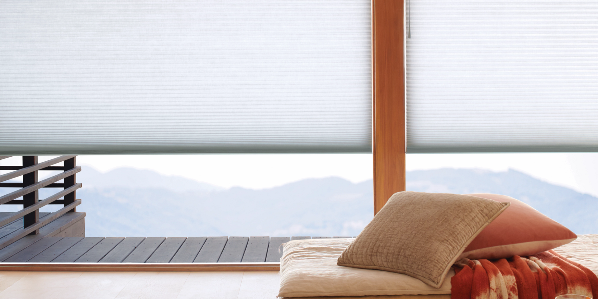 Hunter Douglas cellular shades on expansive windows overlooking a view with mountains in the distanc