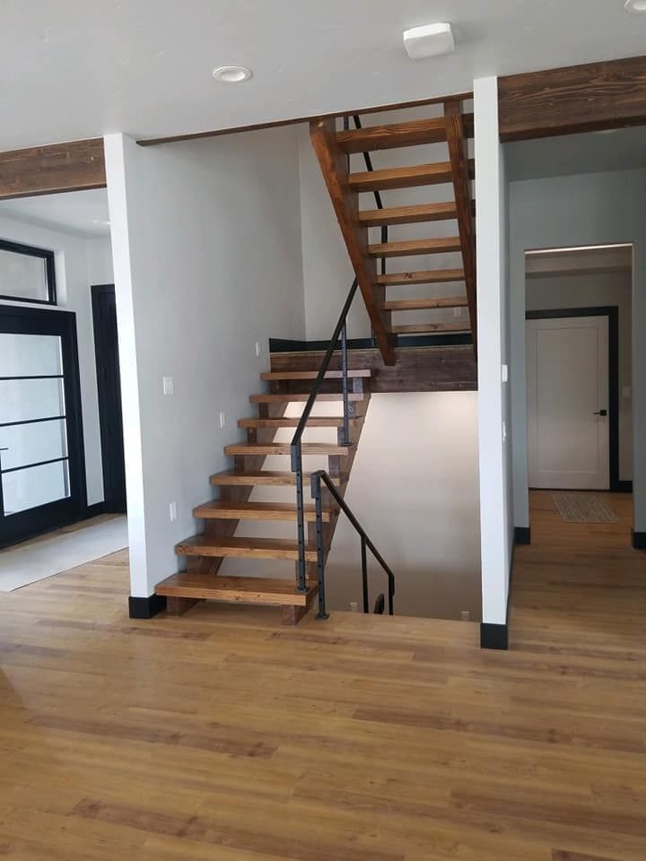 Wooden staircase with black metal railing in a modern home.