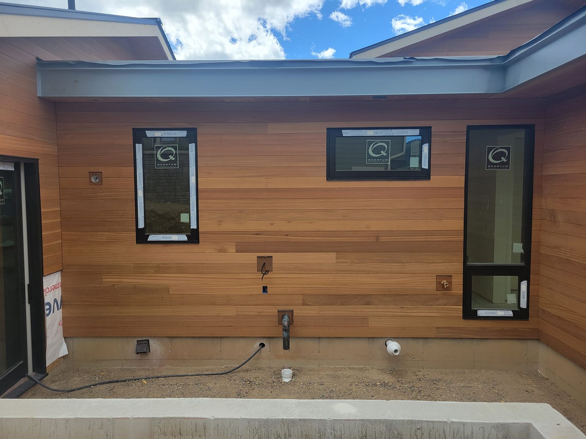 A house with a wooden siding and windows is being built.
