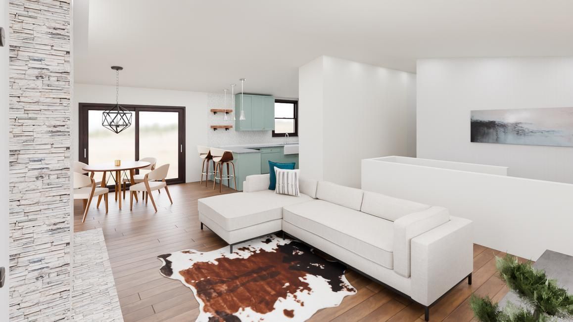 Bright living space: white sectional sofa on cowhide rug, open to dining area with aqua kitchen.