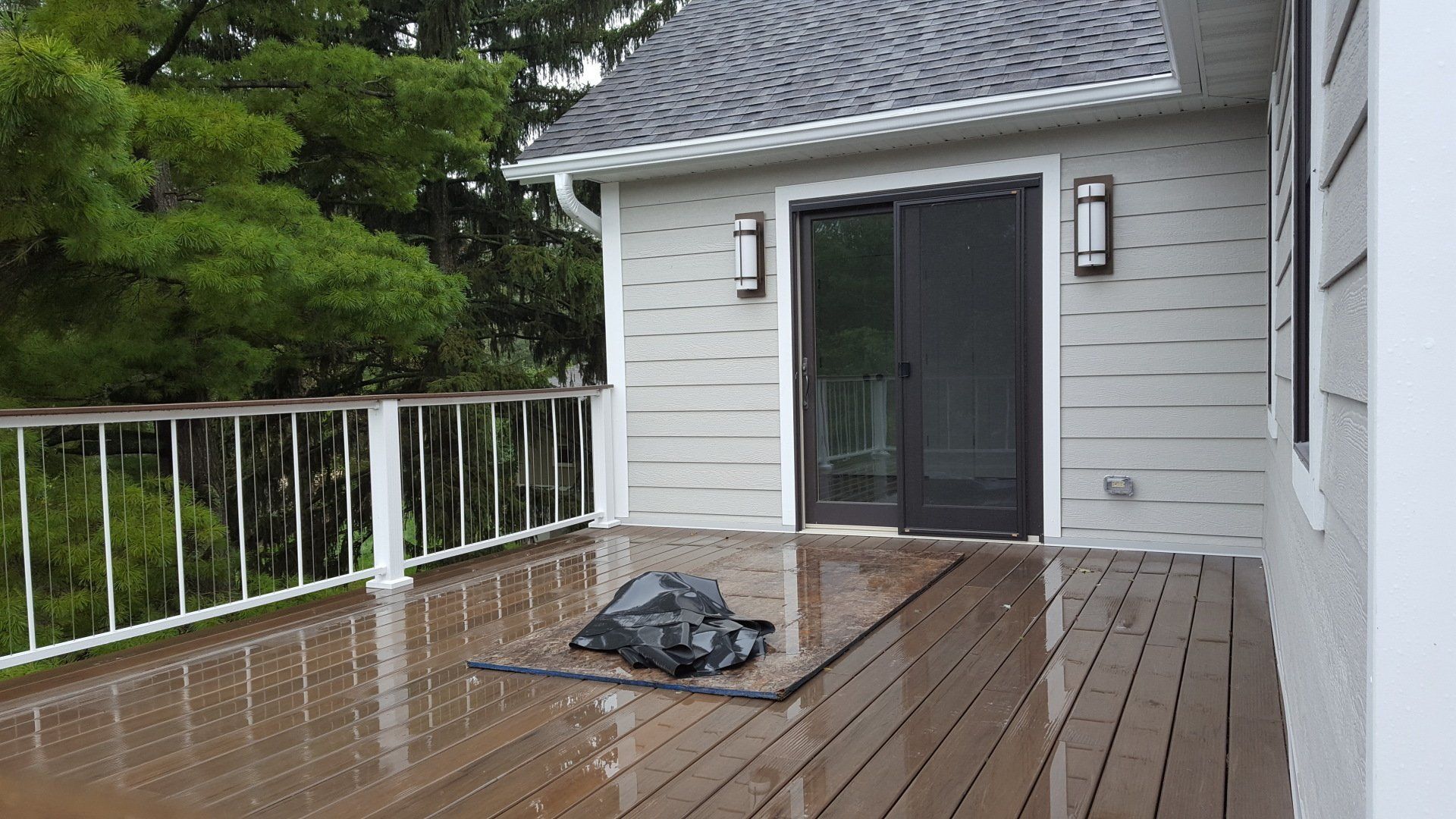 A wooden deck with a bag on it in front of a house.