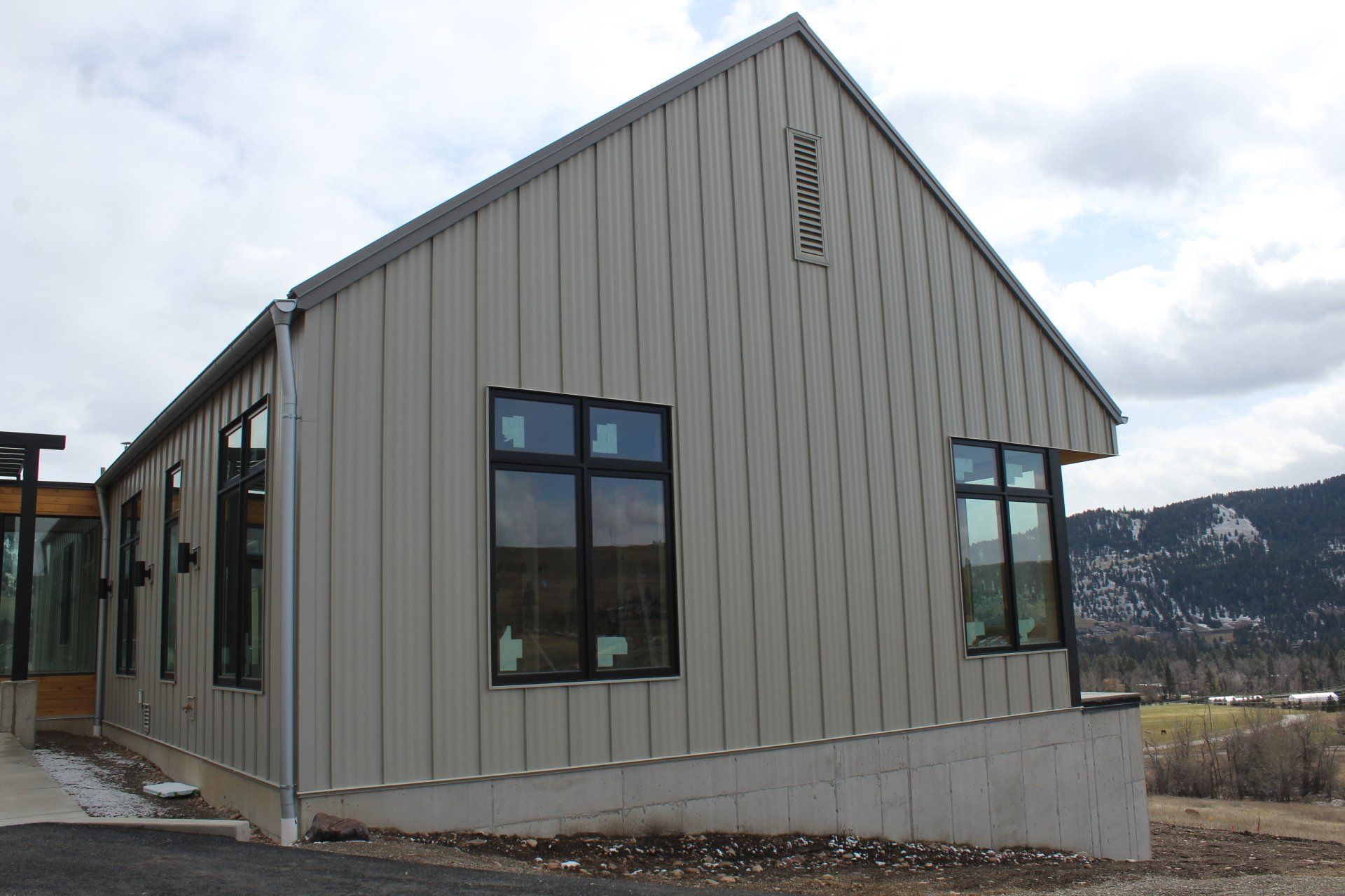 A large building with a lot of windows and a sign on the side that says parking