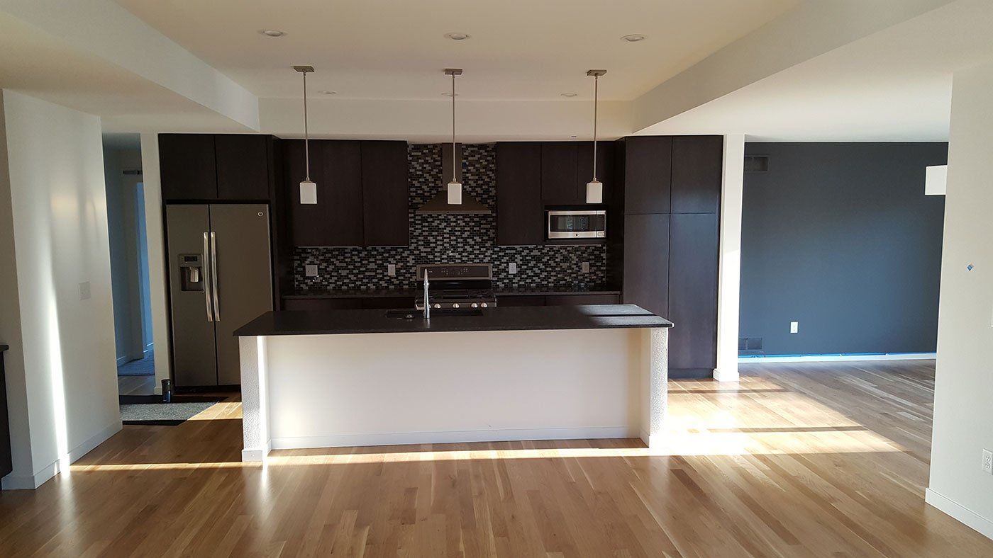 An empty kitchen with a large island in the middle