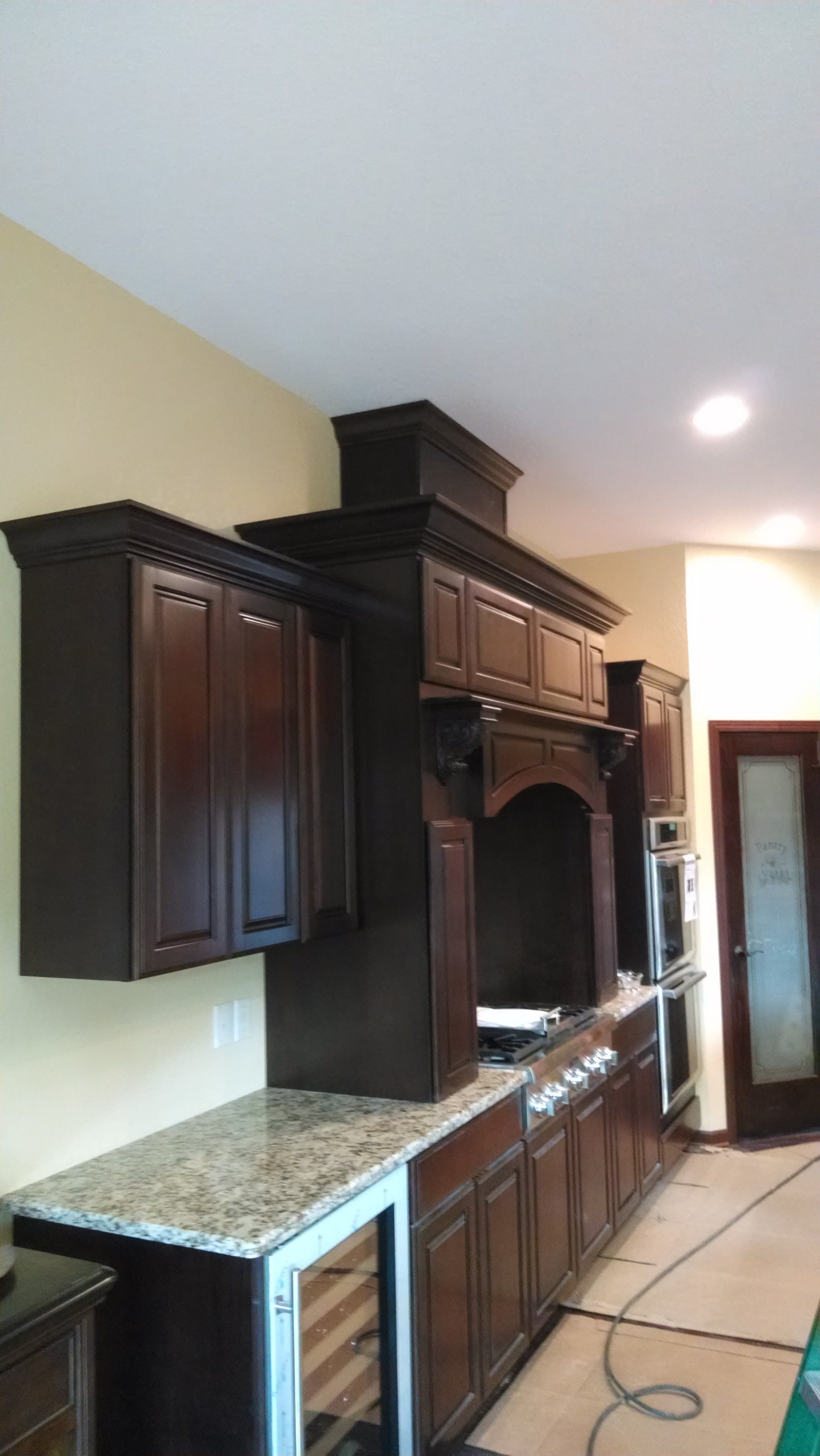 A kitchen with wooden cabinets , granite counter tops , stainless steel appliances and a refrigerator.