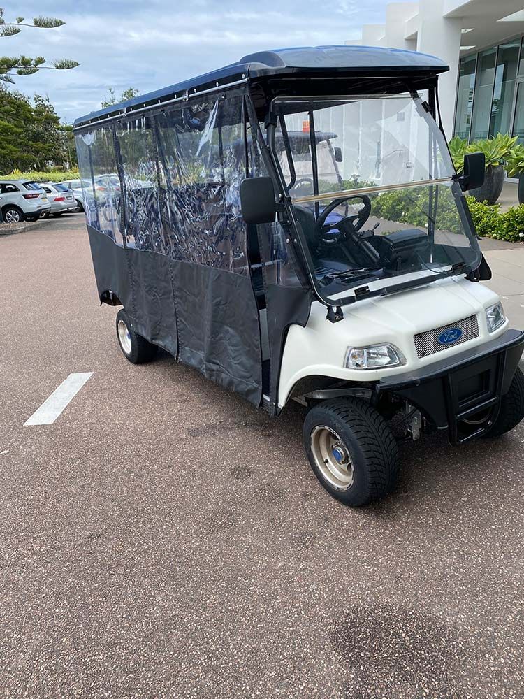 A White Golf Cart is Parked in a Parking Lot — Lift It Equipment in Sydney, NSW