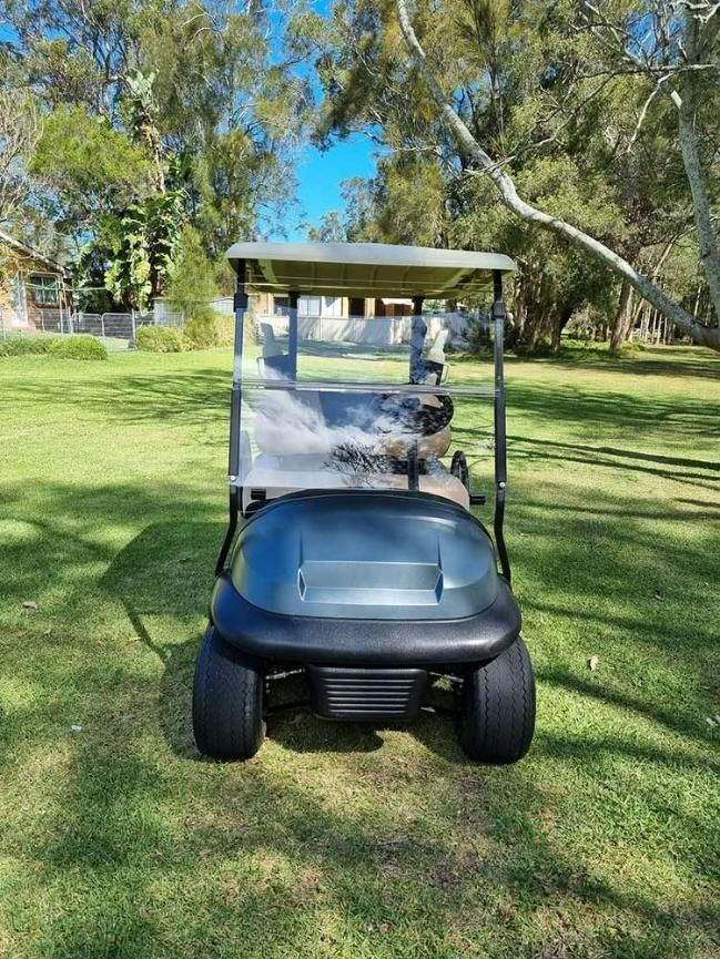 A Golf Cart Is Parked In A Grassy Field — Lift It Equipment in Summerland Point, NSW