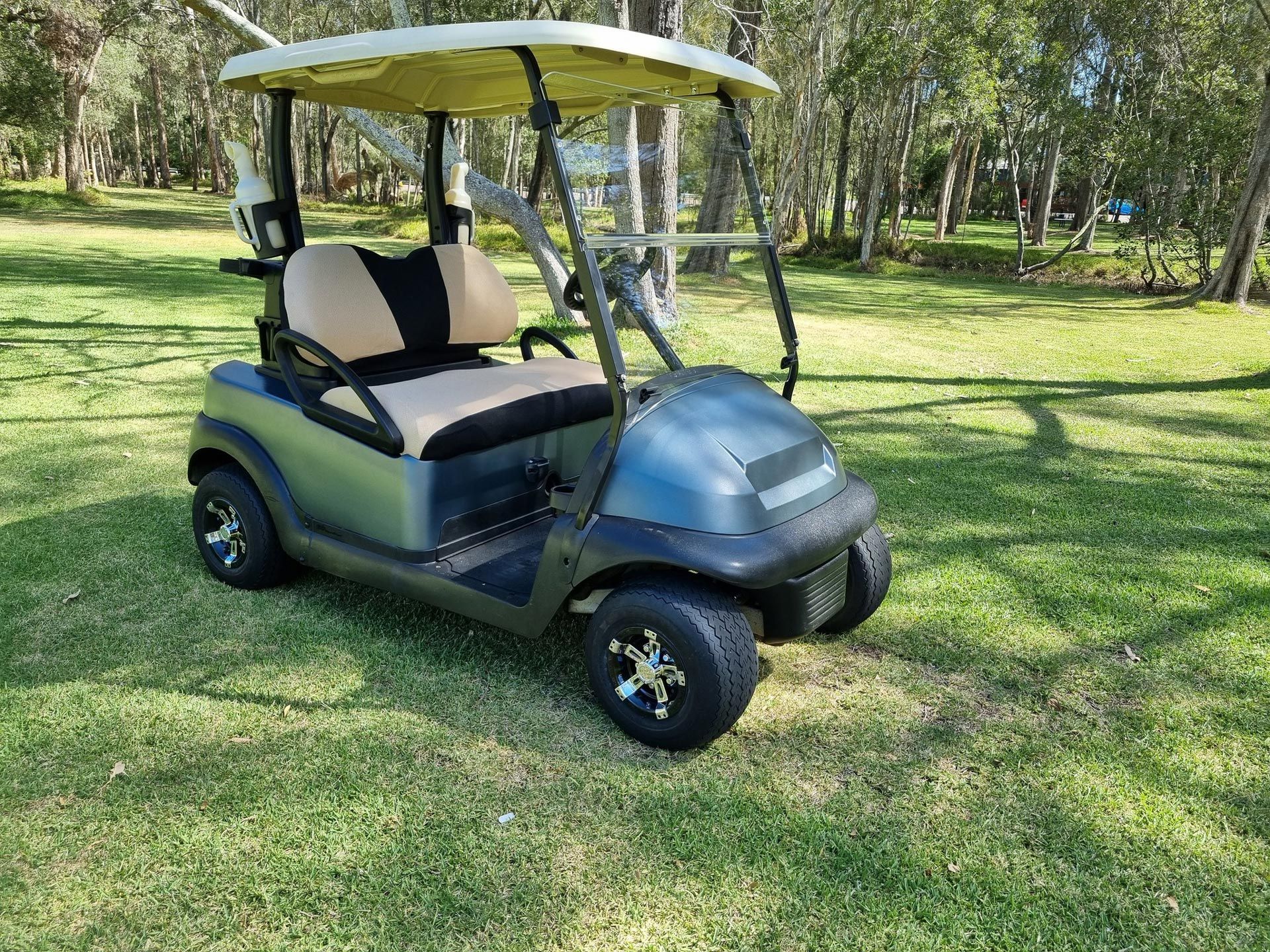A Golf Cart is Parked in the Grass in a Park — Lift It Equipment in Central Coast, NSW