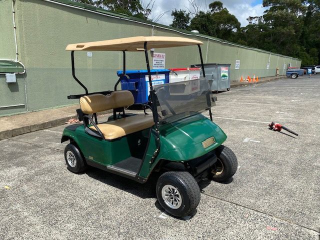 A Green Golf Cart is Parked in a Parking Lot — Lift It Equipment in Central Coast, NSW