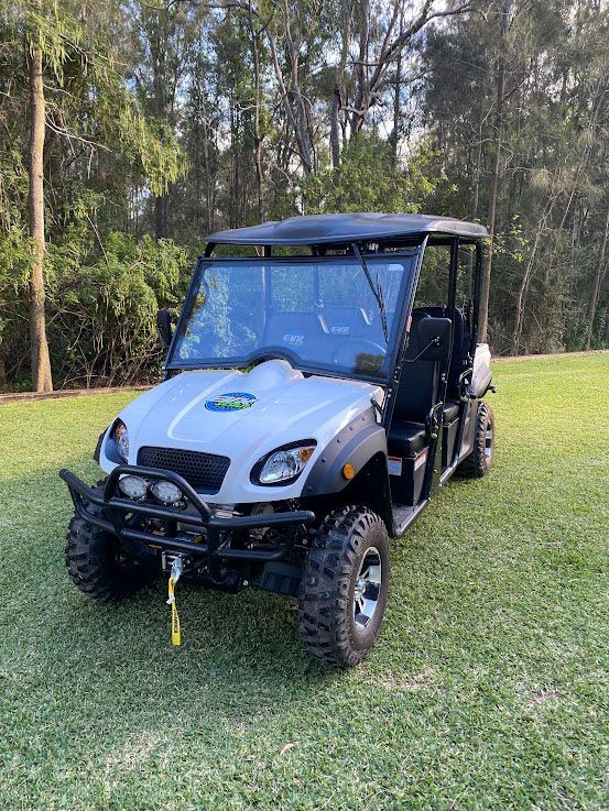A White ATV is Parked in a Grassy Field — Lift It Equipment in Sydney, NSW