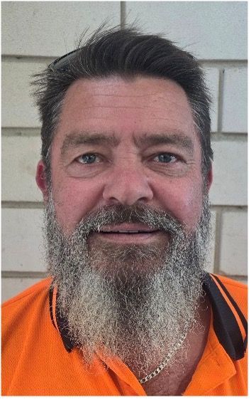 A Man With A Beard Is Sitting At A Table In A Restaurant — Lift It Equipment in Summerland Point, NSW