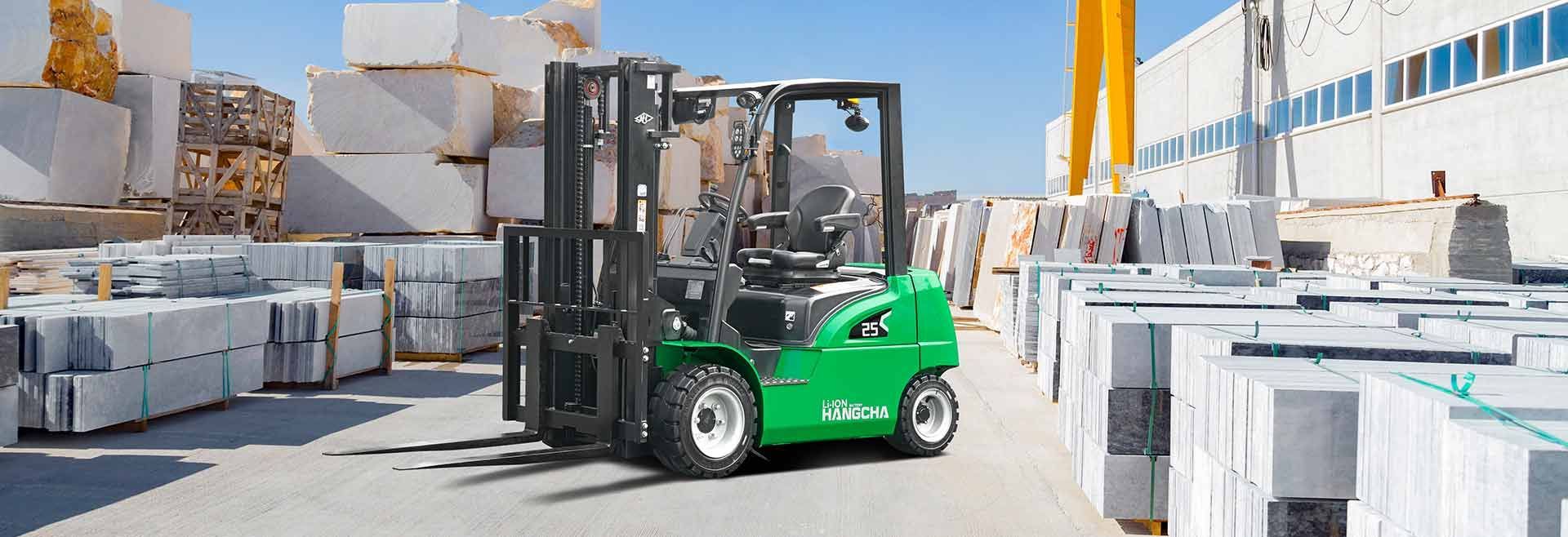 A Green Forklift Is Driving Through A Warehouse Full Of Marble Blocks — Lift It Equipment in Summerland Point, NSW