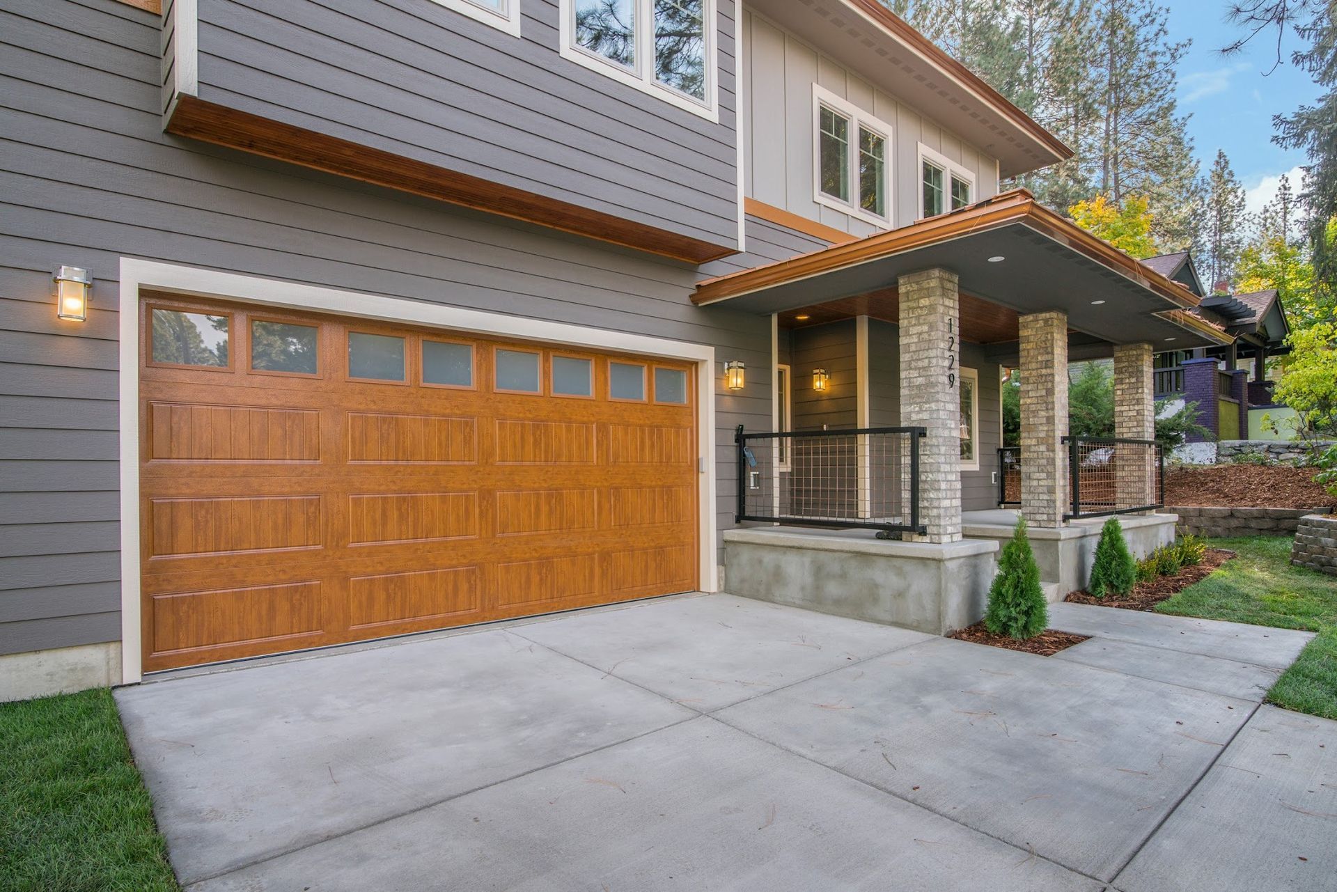 The front porch of a house with a wooden ceiling and stone pillars.