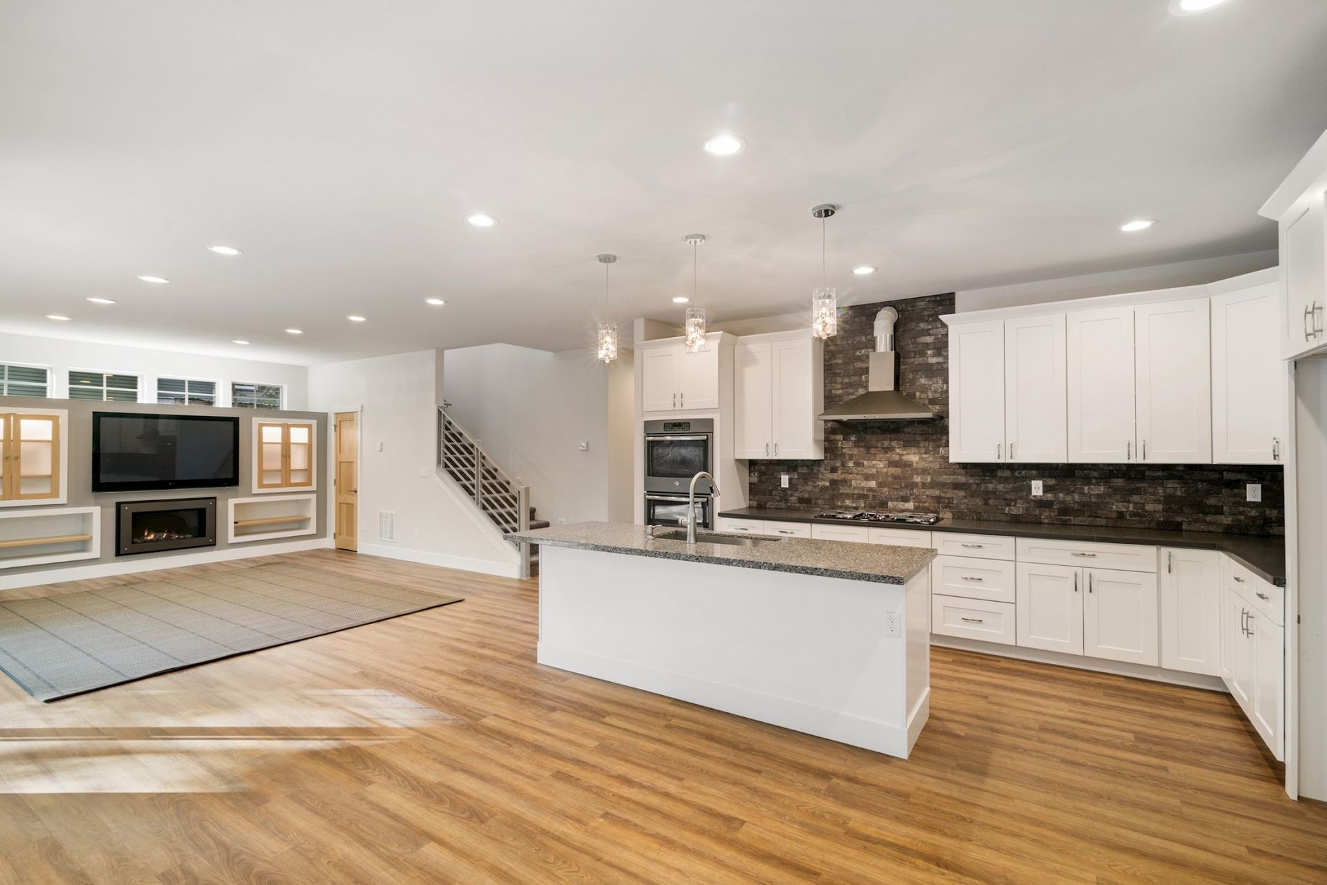 A kitchen with white cabinets and a large island in the middle of the room.