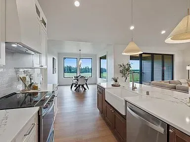 A kitchen with a stove , sink , dishwasher and stainless steel appliances.