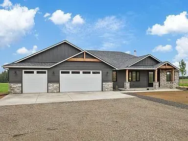 A large house with two garages and a driveway in front of it.