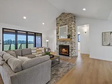 A living room with a couch , fireplace , and large windows.