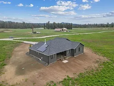 An aerial view of a house in the middle of a grassy field.