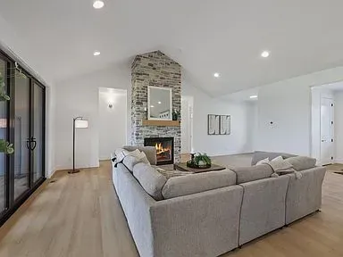 A living room with a couch , fireplace , and mirror.