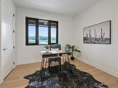 A home office with a desk , chair and rug.