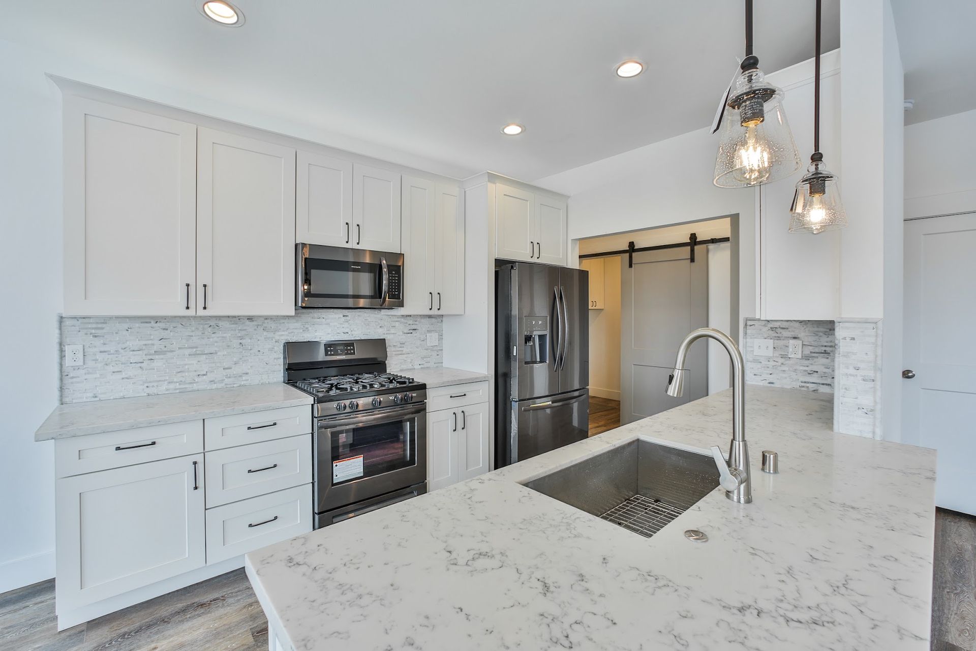 A kitchen with white cabinets and stainless steel appliances