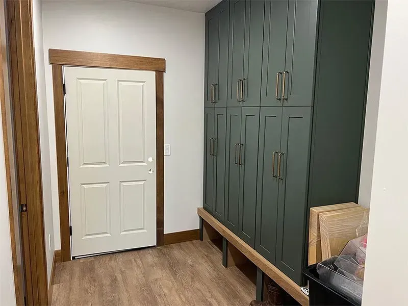 A hallway with lots of cabinets and a door.