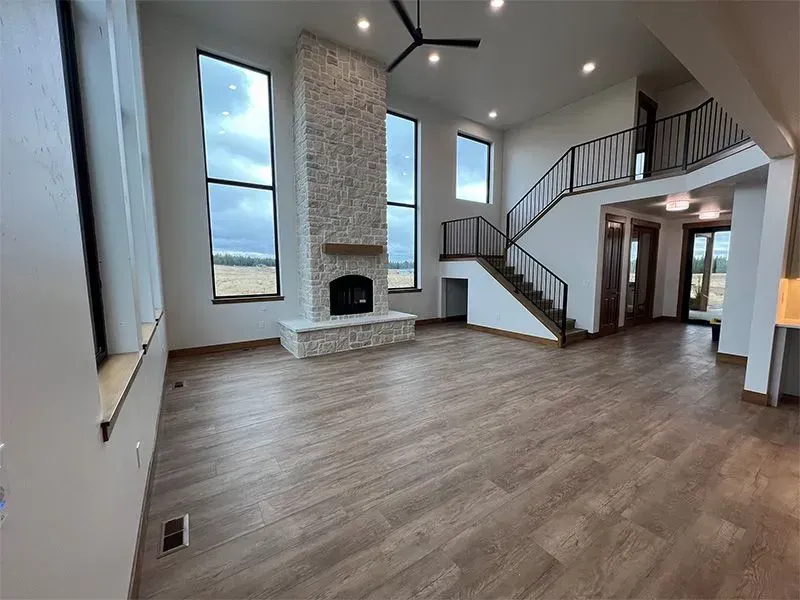 A living room with a fireplace and stairs in a house.