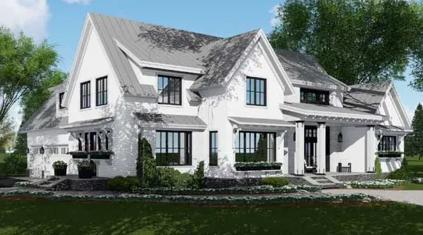 A large white house with a gray roof is sitting on top of a lush green field.