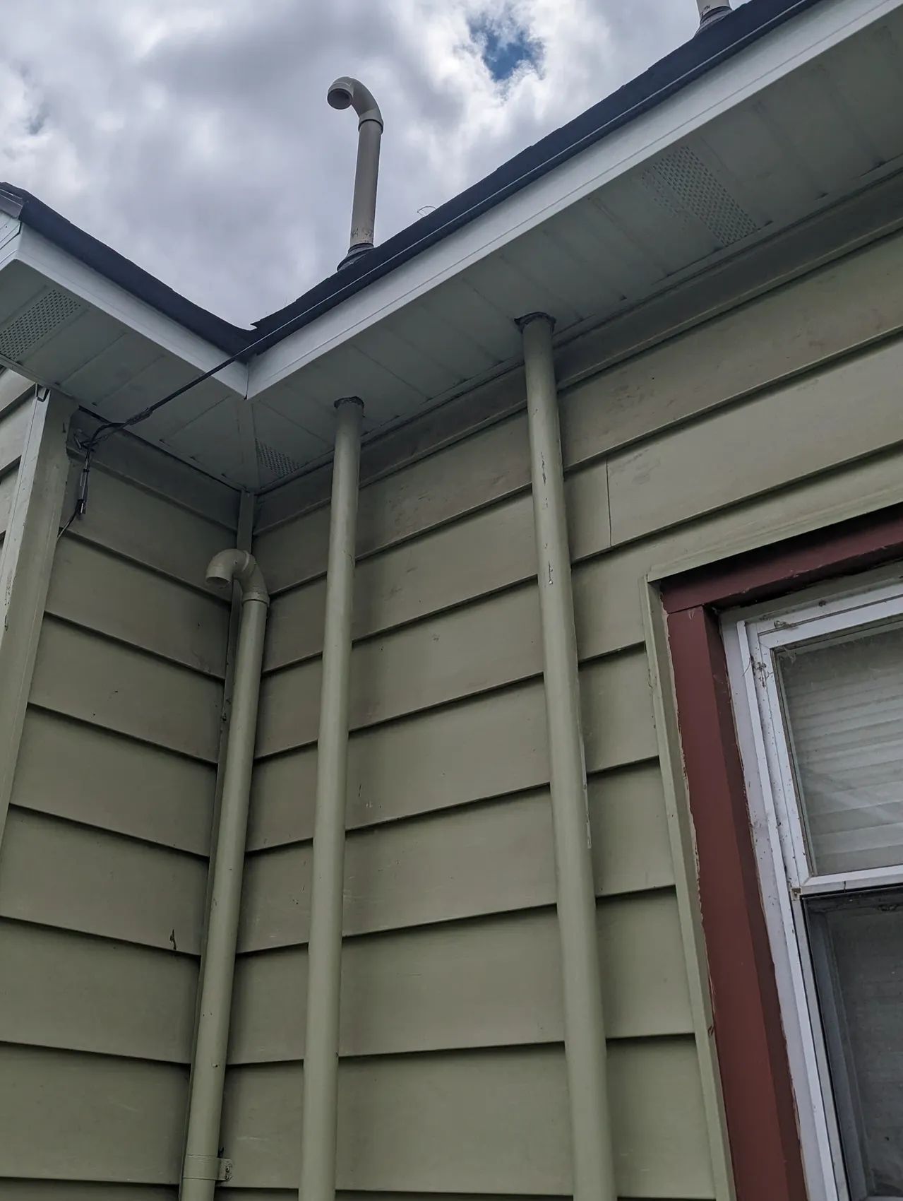 A house with a chimney on the roof and a window.