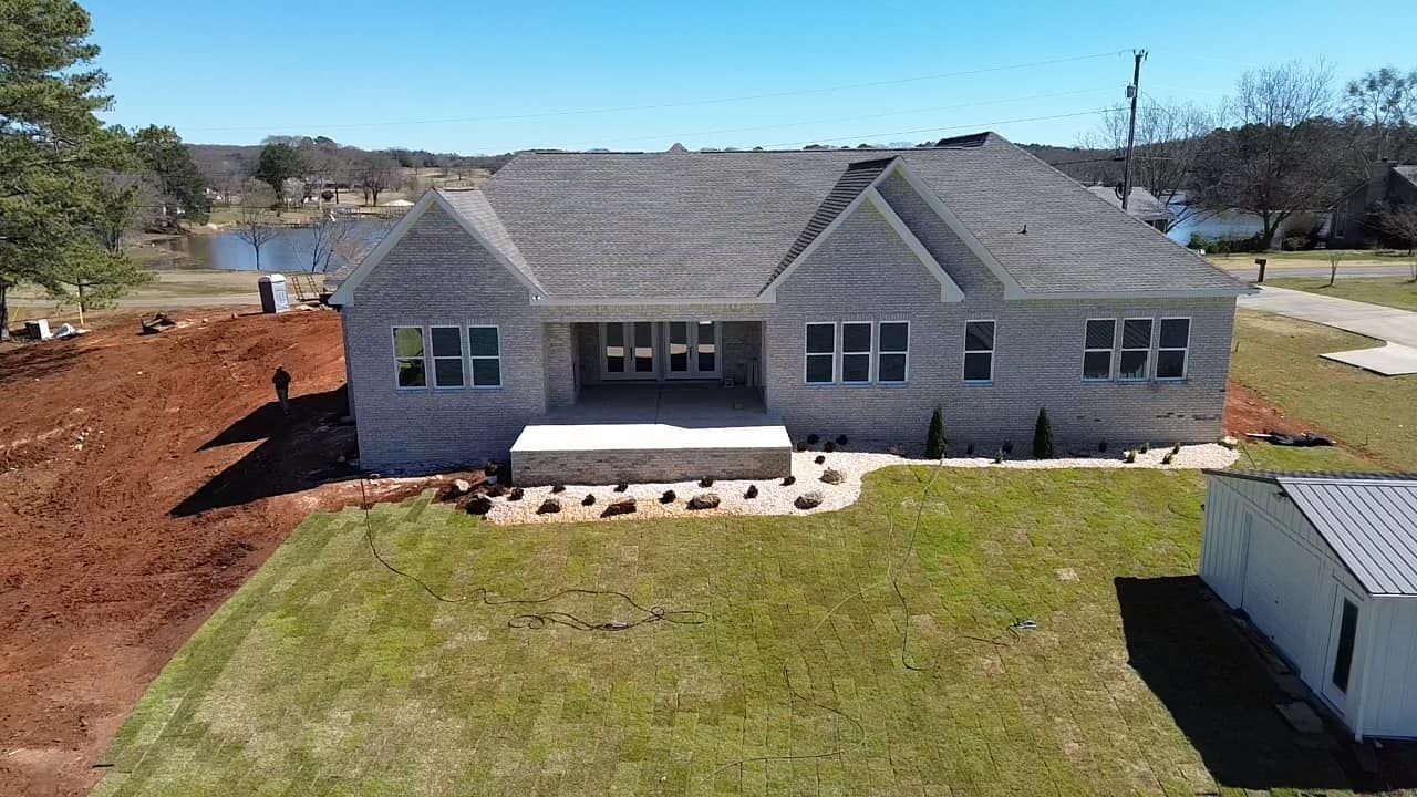 Vibrant green grass with light and dark striped patterns curving across a mowed lawn.
